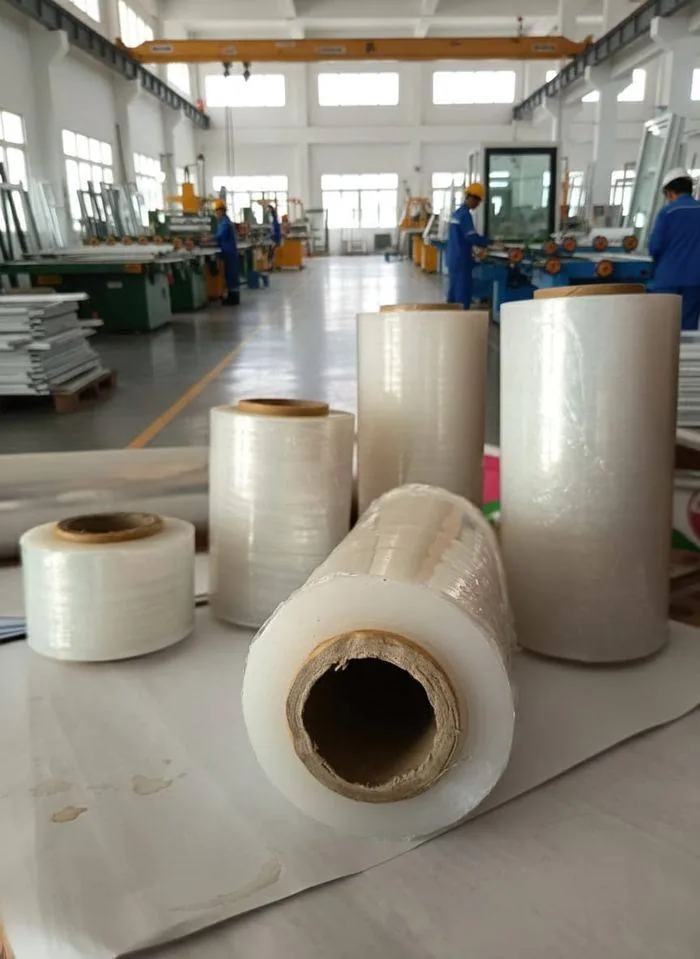 Karyawan gudang menangani rol plastik wrapping stretch film Harmony