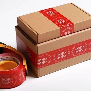 Rol lakban custom printing merah berlogo Rokokku pada kemasan kardus